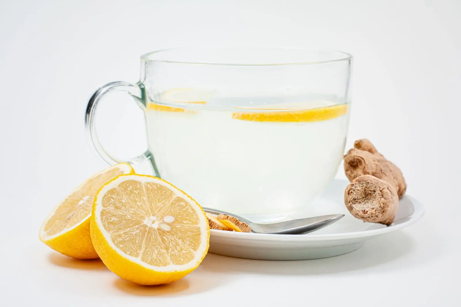 Cup of lemon and ginger tea with fresh lemon slices and ginger root