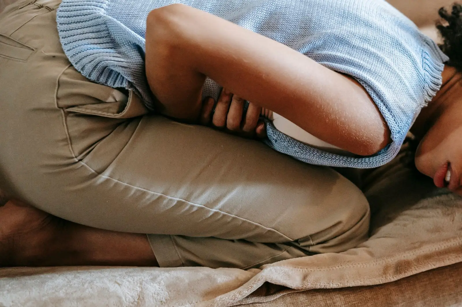 Woman resting on a sofa with her hand on her stomach