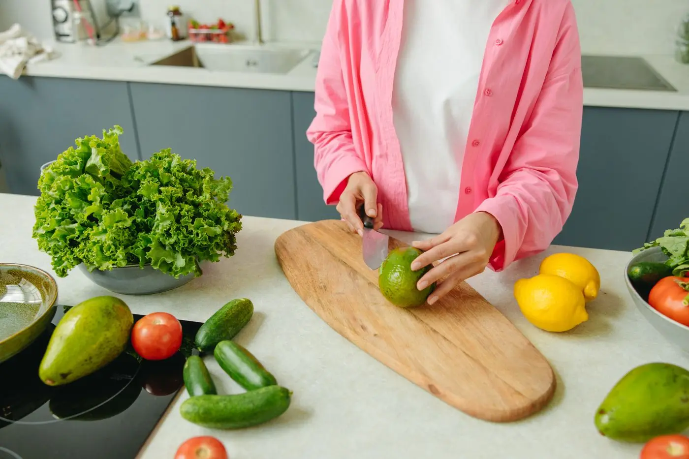 Person chopping fresh vegetables on a wooden board
