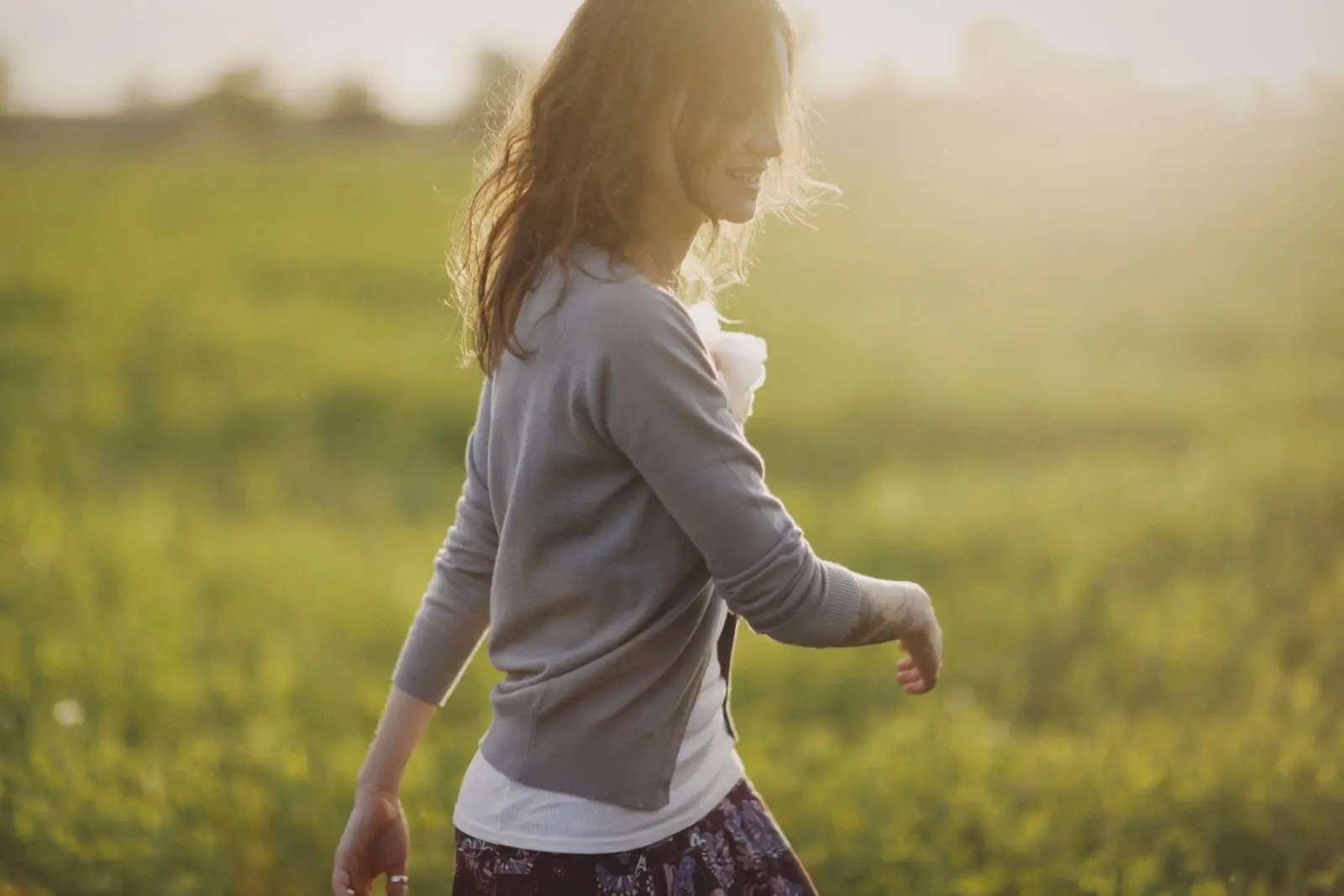 Woman walking through a sunlit field