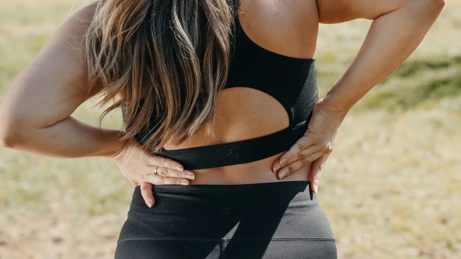 Woman holding her lower back to ease a common pregnancy ache