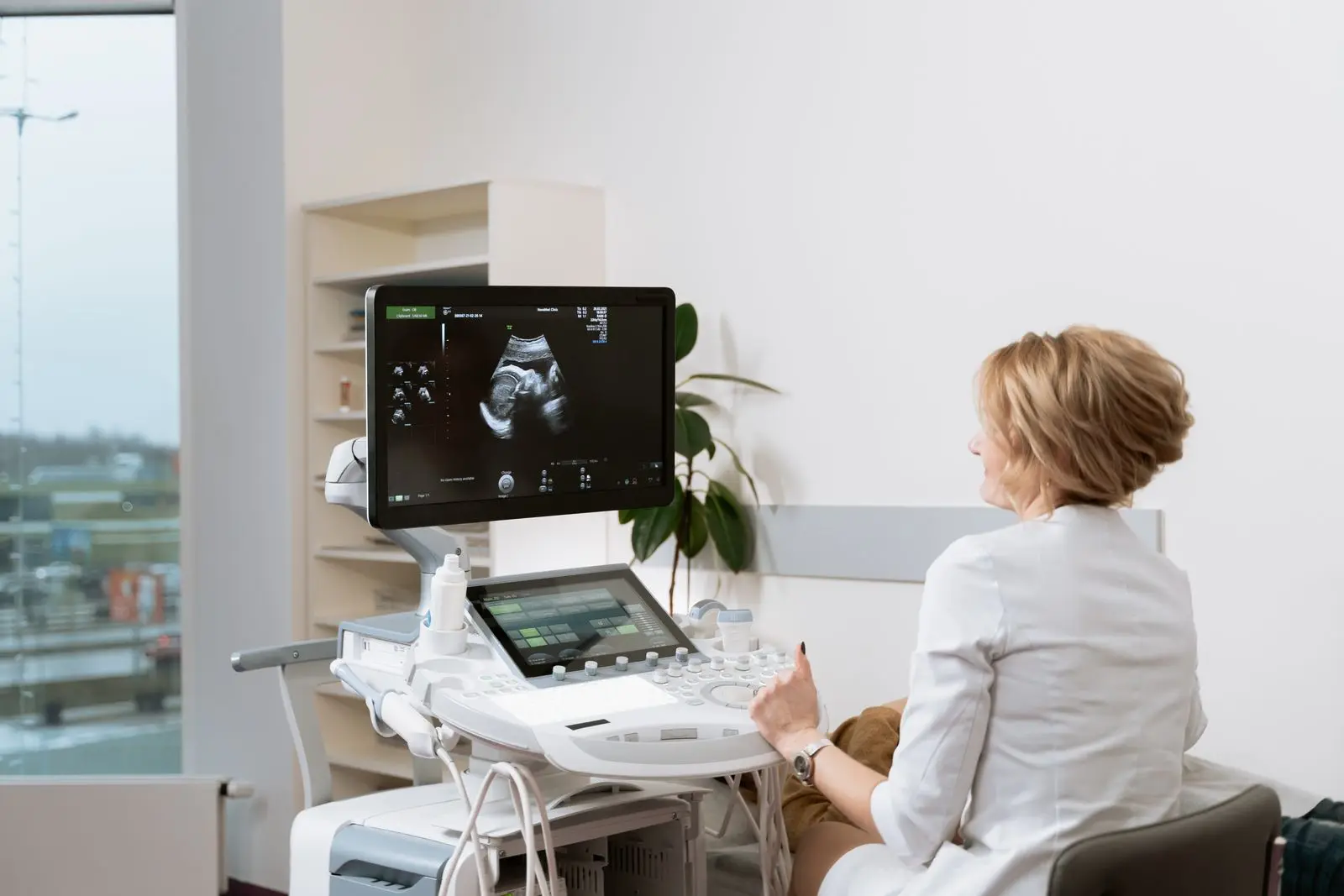 Doctor performing an ultrasound scan on a pregnant patient in a clinic
