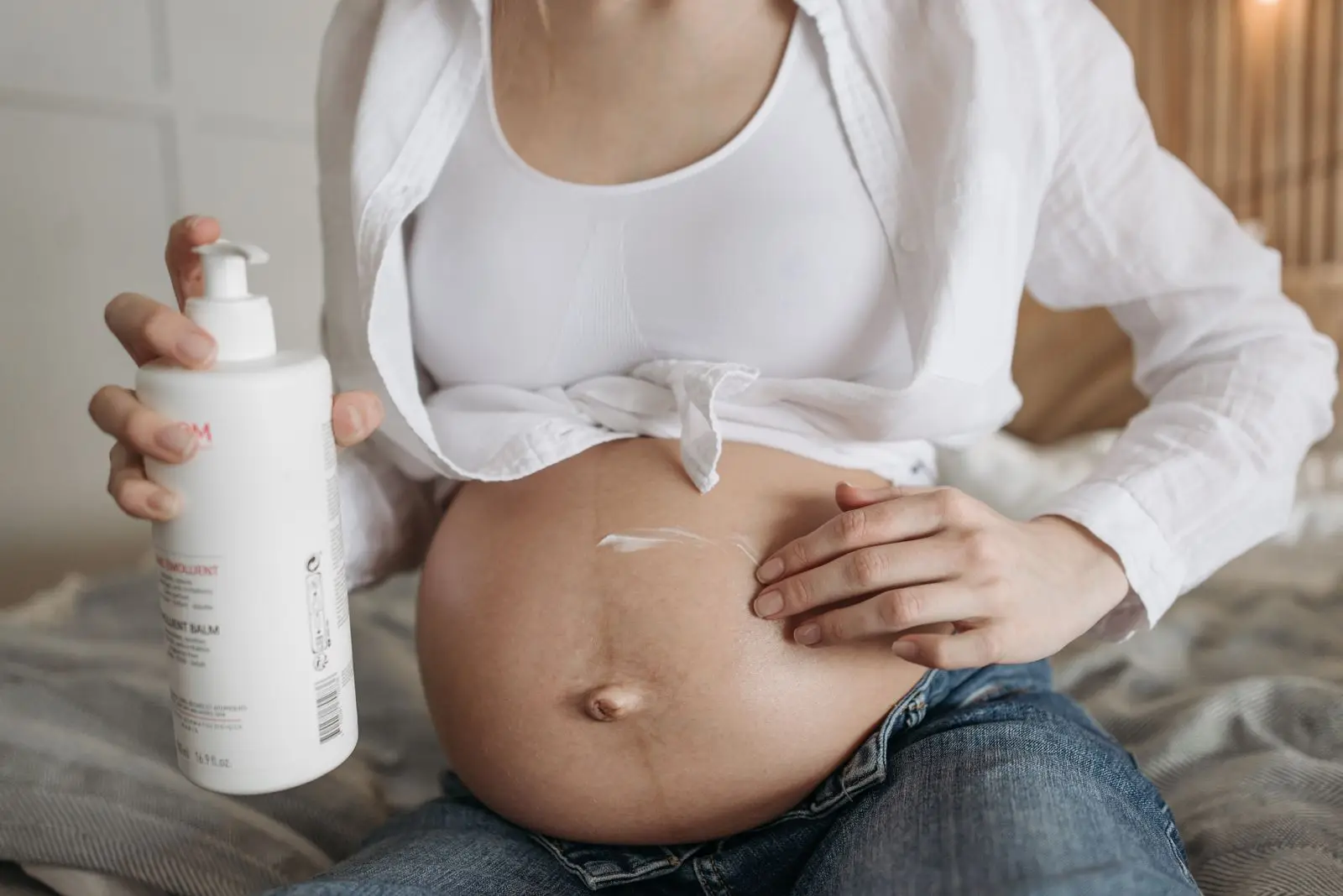 Pregnant woman applying belly balm to her baby bump