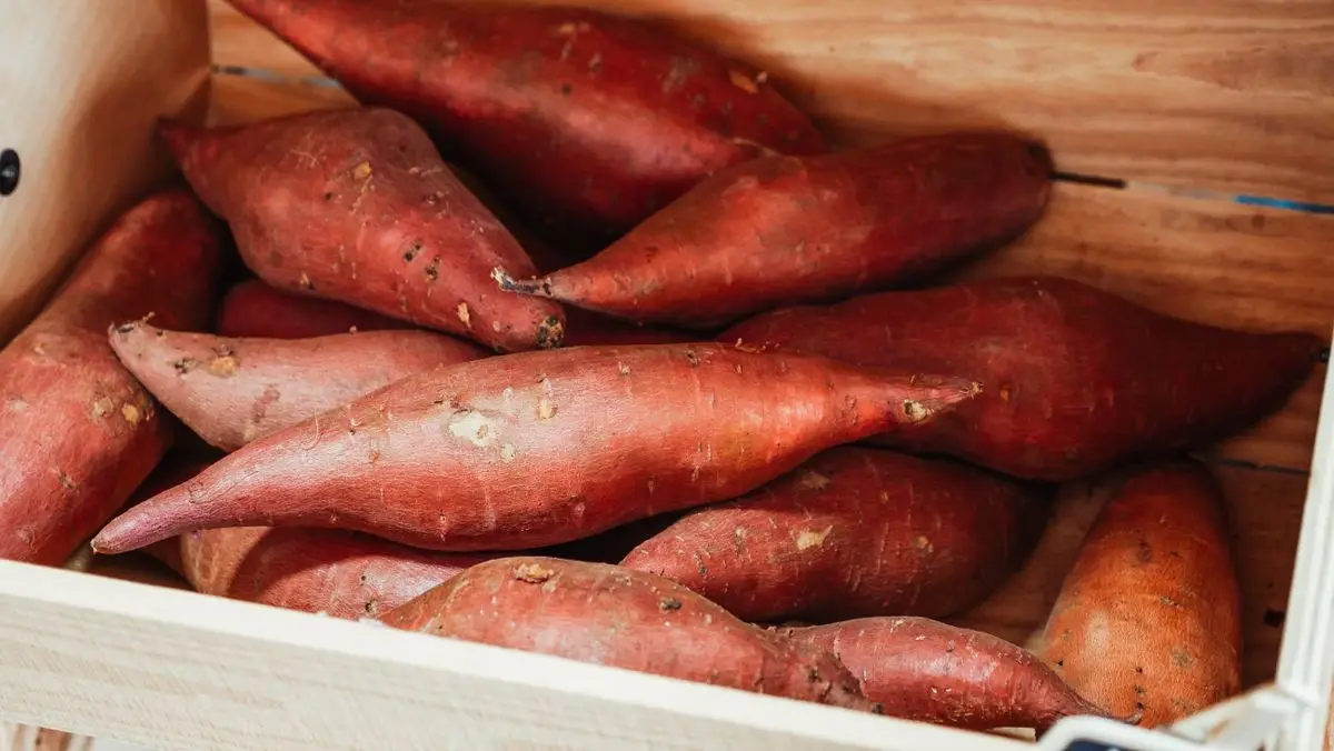Sweet potatoes in a wooden crate, about the size of your baby at 22 weeks pregnant
