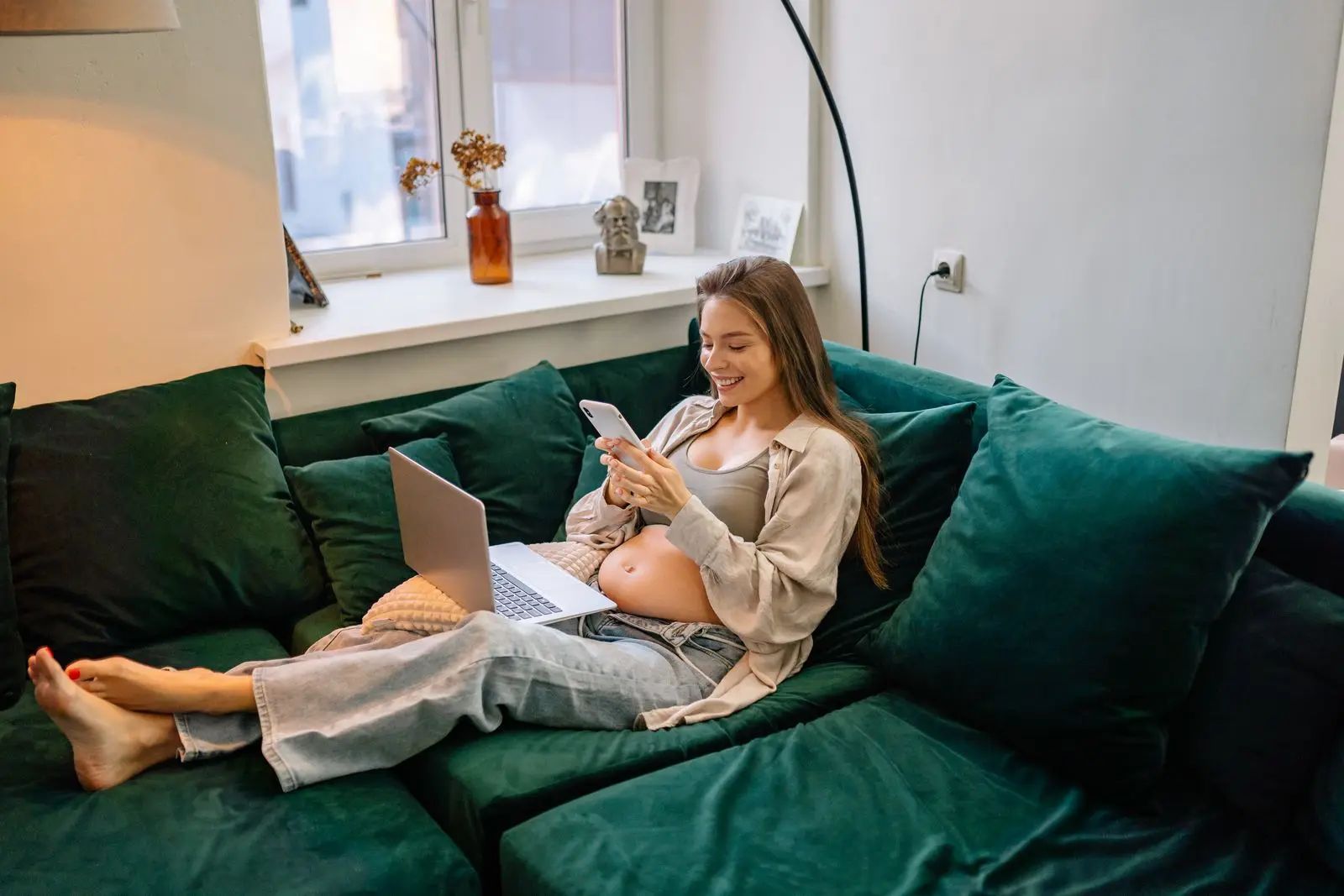 Pregnant woman sitting on a green sofa taking a rest