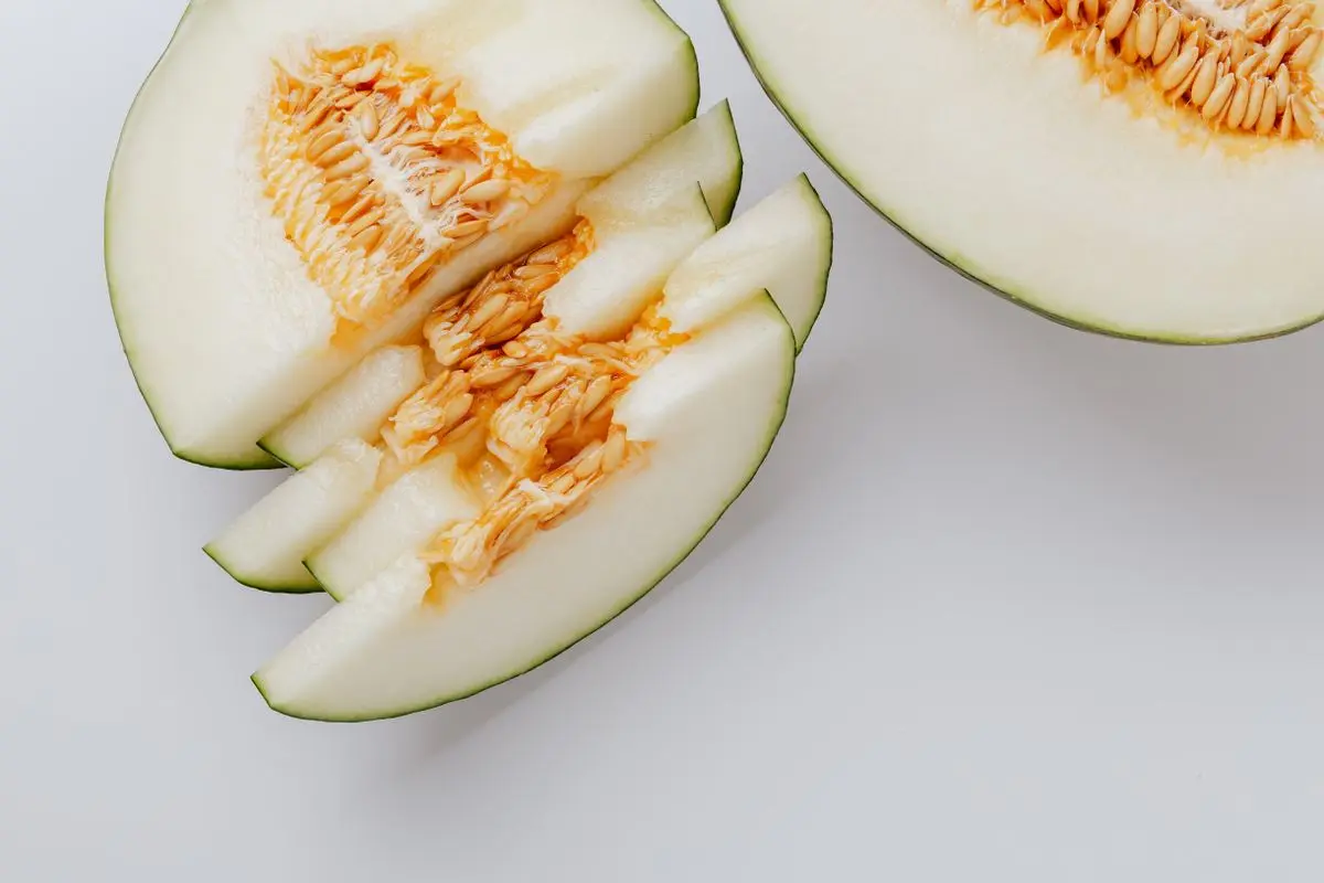 Sliced honeydew melon showing its seeds and pale flesh, about the size of your baby at 35 weeks pregnant