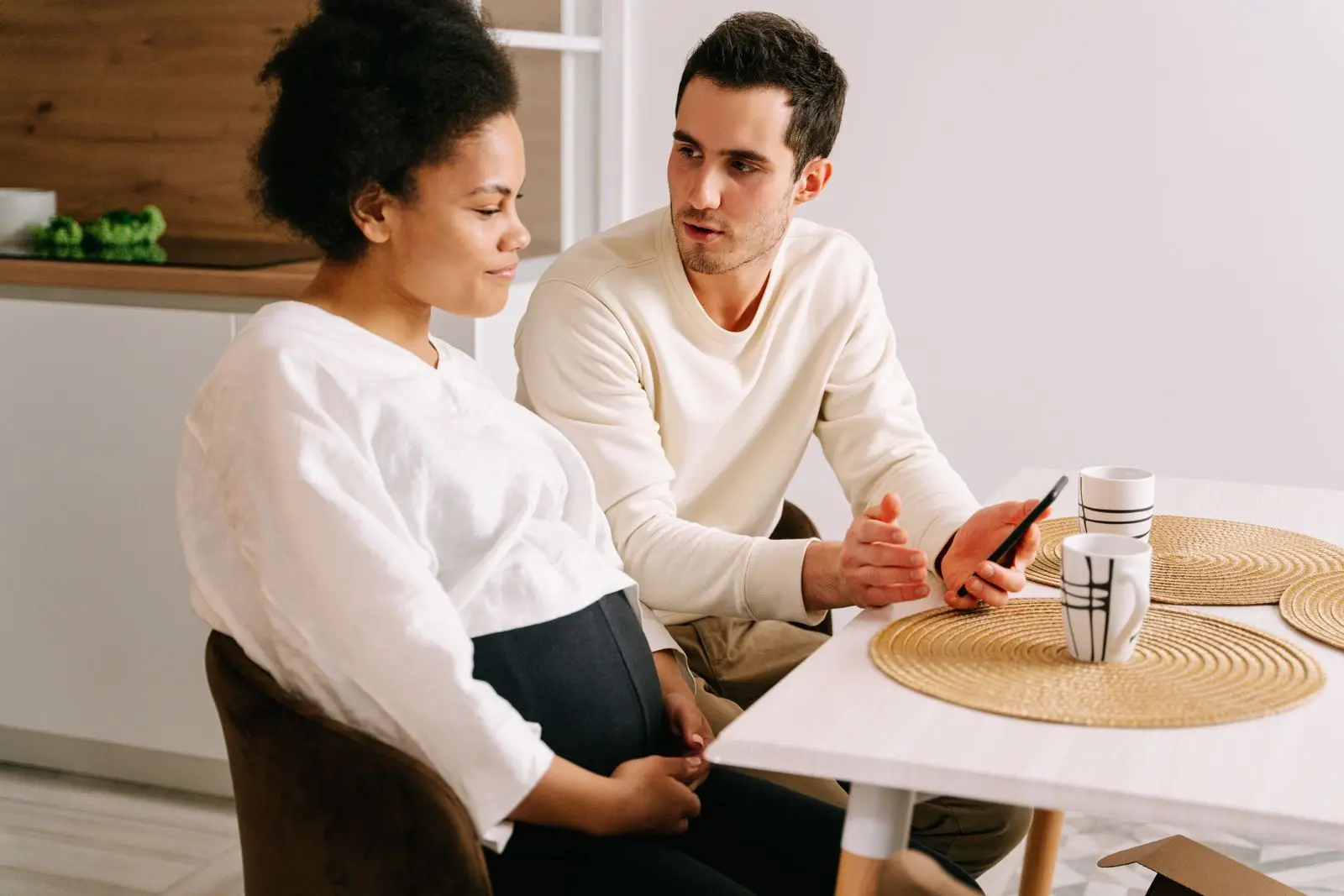 Couple talking about planning a pregnancy at the kitchen table