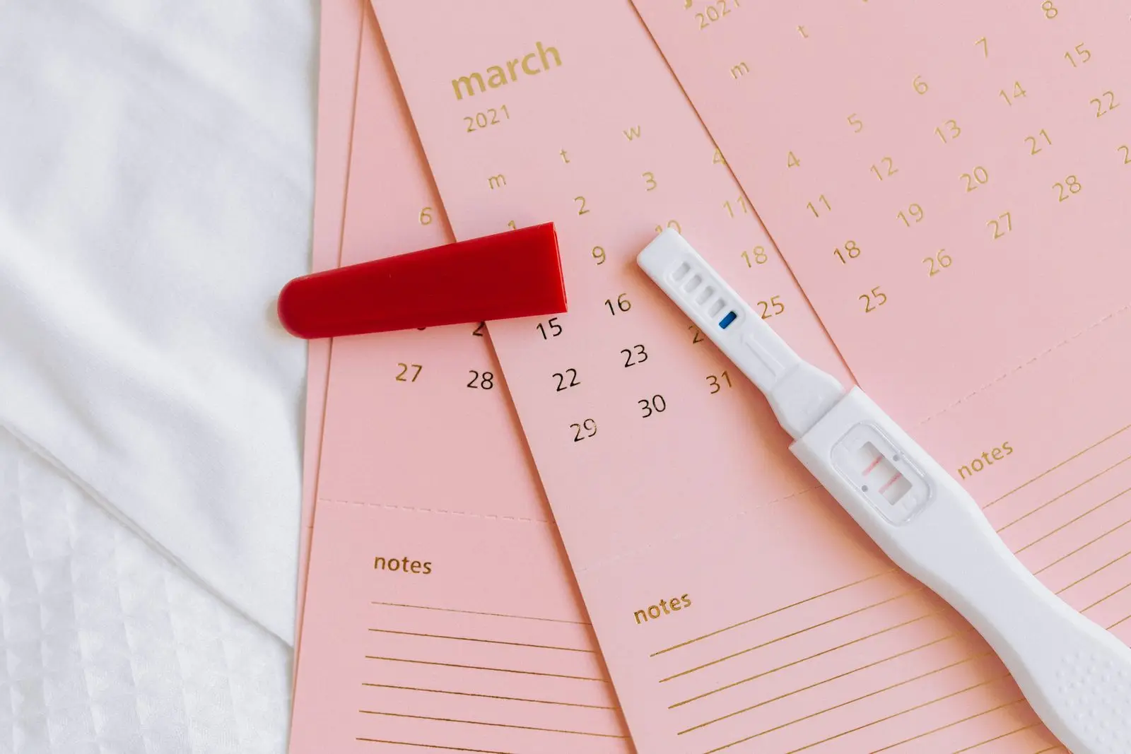 Pregnancy test resting on calendar cards